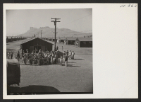 [recto] Residents of the Tule Lake Center gather around the assembly point to bid goodbye to friends and relatives being transferred to Heart Mountain. ;  Photographer: Mace, Charles E. ;  Newell, California.