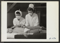 [recto] Registered Nurse, Mrs. Edythe Sasser, is assisted by Yoshiko Konatsu, Nurse's Aid, and Tomiko Kitasaki, Nurse's Aid, in the treatment ...