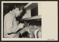 [recto] A shoemaker busy on a machine in a shoe repair shop at the center. With all available shoemakers at work, ...
