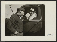 [recto] Pete Zimbleman, who with his brother harvested 280 acres of sugar beets, here instructs an evacuee, who is driving a beet truck, and who intends to remain in the employ of Mr. Zimbleman after the beet harvest. ;  Photographer: Parker, Tom ;  Keensburg