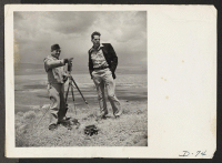 [recto] Tule Lake, Newell, Calif.--Captain Patterson shows Walter Fuesler, architect, the view from a hilltop near this War Relocation Authority center, which can be seen in the background. ;  Photographer: Stewart, Francis ;  Newell, California.