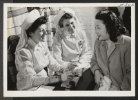 [recto] Mrs. Margaret Plotkin, left, and Mrs. Roy W. Wallace, Red Cross staff assistants, register Mrs. Jean Kuroda, Japanese-American evacuee from ...