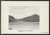 [recto] Looking between two rows of barracks at the Salinas Assembly Center. ;  Photographer: Albers, Clem ;  Salinas, California.