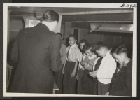[recto] Boy Scouts hold a Court of Honor at Central Utah Relocation Center. Deputy Director James F. Hughes presents merit badges to first class scouts. ;  Topaz, Utah.