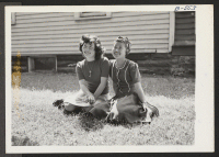 [recto] May Mukai (left) and Florence Uyeda, Japanese-American girls who formerly lived at the Central Utah Relocation Center, in front of ...