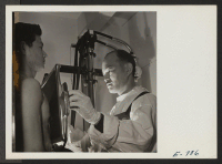 [recto] A former Californian, Dr. Fujikawa, examining a patient, S. Ego, in the center hospital fluoroscope. ;  Photographer: Parker, Tom ;  Denson, Arkansas.