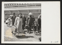 [recto] San Bruno, Calif.--Family of Japanese ancestry arrives at assembly center at Tanforan Race Track. Evacuees will be transferred later to War Relocation Centers where they will be housed for the duration. ;  Photographer: Lange, Dorothea ;  San Bruno, C