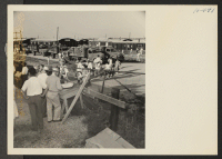 [recto] Closing of the Jerome Center, Denson, Arkansas. W.R.A. officials and transportation officers check out the truck load of Jerome residents as they pass through the gate to the tracks where they are to entrain for the Gila River Center. ;  Photographer: M
