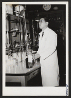 [recto] An exacting measurement--Mr. Harold Arase, Jerome, concentrates on his work in the laboratory of the Lankenau Hospital, Philadelphia. ;  Philadelphia, Pennsylvania.