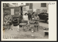 [recto] The backyard garage of Yam Okamuro in Glendale, California. Left to right, Mr. Okamuro, Dennis Okamuro (Mrs. Hara's little nephew), ...