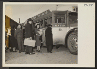 [recto] Scene at the Heart Mountain, Wyoming, Bus Depot. Mr. and Mrs. Robert Yoshio Kodama and their small son, Junior, are ...