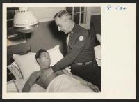 [recto] Pfc. James Oshiro being examined by Major Rotherwell in charge of physio-therapy at Moore General Hospital, Swannanoa, North Carolina. Pvt. ...