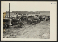 [recto] Closing of the Jerome Center, Denson, Arkansas. Farm equipment assembled in the Jerome motor pool showing trucks and other vehicles assembled for shipment to the Rohwer Center. ;  Photographer: Mace, Charles E. ;  Denson, Arkansas.