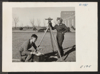 [recto] Kataro Murai, left, and fellow student doing some field work in engineering at the University of Nebraska. ;  Photographer: Parker, Tom ;  Lincoln, Nebraska.