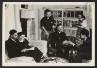 [recto] A pleasant homelike atmosphere at the American Friends Hostel in Des Moines, Iowa. Shown in the living room are, left ...