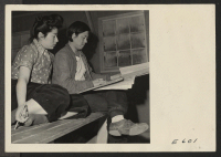 [recto] Benji Okuda, well known artist of Japanese ancestry, sketches a few pointers for a student in an adult art class at the Heart Mountain Relocation Center. ;  Photographer: Parker, Tom ;  Heart Mountain, Wyoming.