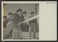 [recto] A practice fire drill gives the local fire department the necessary practice to handle any emergency which might arise. ;  Photographer: Stewart, Francis ;  Manzanar, California.