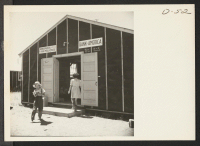 [recto] A view of the bank and newsstand at this War Relocation Authority center for evacuees of Japanese ancestry. The bank is open on Tuesdays and Fridays only. ;  Photographer: Stewart, Francis ;  Newell, California.