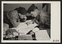 [recto] San Pedro, Calif.--Lieutenant James Glatt (left), and Lieutenant Cal Ferris (right) complete last minute evacuation details as the last 300 residents of Japanese ancestry leave their Redondo Beach homes for assembly center at Arcadia, California. ;  Pho