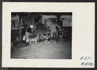 [recto] Adobe factory. Women workers scraping mortar into adobe frames. ;  Photographer: Stewart, Francis ;  Poston, Arizona.