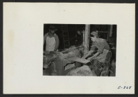 [recto] Two workmen in the cabinet shop, constructing furniture for school and center office use, operating a planer. ;  Photographer: Lynn, Charles R. ;  Denson, Arkansas.