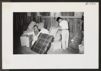 [recto] Persons transferred from Tule Lake on the first train claimed their checkable baggages in Recreation Hall 17 a day or two after arrival. ;  Photographer: Lynn, Charles R. ;  Denson, Arkansas.