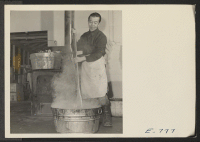[recto] In a corner of a laundry building, Mr. I. Telashita stirs a tub of rendered fats, in preparing soap for ...