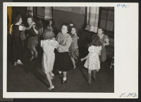 [recto] Children in an afternoon class at the Christopher House in Chicago, learning folk dances under the direction of Tetsu Sugi. ...