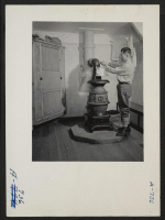 [recto] View of the house of Eizo Nishi. The pot bellied stove shown in this photo burns coal and provides ample heat. Present occupation: none. Former occupation: hotel business. Former residence: Seattle, Washington. ;  Photographer: Stewart, Francis ;  Hun