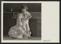 [recto] Mrs. Kinoshida, the Russian wife of a center minister of Japanese ancestry, throws a male instructor in a Judo class at the Heart Mountain Relocation Center. ;  Photographer: Parker, Tom ;  Heart Mountain, Wyoming.