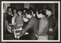 [recto] Community singing is still a popular pastime as evidenced by the group shown here. The Caucasian seated at the piano is the ... secretary of the Young Kansas Citians' Club. ;  Kansas City, Missouri.