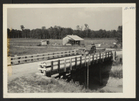 [recto] Closing of the Jerome Center, Denson, Arkansas. One of the bridges built by Jerome evacuees over one of the large drainage canals in the center's extensive agricultural area. ;  Photographer: Mace, Charles E. ;  Denson, Arkansas.