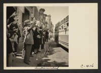 [recto] Inhabitants of the Japanese section wave farewell at the departure of their friends and neighbors whom they are soon to ...