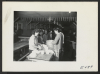 [recto] A kitchen crew wiping the last remnants of the evening dishes in a resident mess hall. ;  Photographer: Parker, Tom ;  Amache, Colorado.