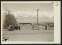[recto] Entrance, during construction, of this War Relocation Authority center for evacuees of Japanese ancestry in Owens Valley, flanked by High Sierras and Mt. Whitney, United States' loftiest peak. ;  Photographer: Albers, Clem ;  Manzanar, California.
