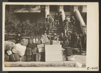 [recto] San Francisco, Calif. (2031 Bush Street)--The baggage of evacuating Japanese has been brought in and piled on the sidewalk across the street from the WCCA Control Station and a group looks on at this scene of first evacuation from this district. ;  Phot