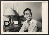 [recto] Lani Kai, Hawaiian born Nisei, is shown in his New York City room. Lani was evacuated to Manzanar from Los ...
