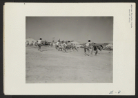 [recto] Tough football, as practiced by these young residents at the Topaz center, develops into a very rough game indeed, despite the lack of gear or any suitable equipment. ;  Photographer: Parker, Tom ;  Topaz, Utah.