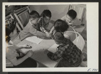 [recto] In a pre-school class at the Jerome Center, young residents reach for the crayon box, under the supervision of assistant teacher Emiko Shinagawa. Children, left to right, are: Hidemi Kimura, Tomiko Fukute, Shigea Konishi, Alfred Miyamoto, and Sei Asaki.