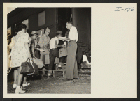 [recto] Closing of the Jerome Center, Denson, Arkansas. Typical scene in the chair car entrances as WRA officials and Military Police checked the passengers and assisted them up the steps. ;  Photographer: Iwasaki, Hikaru ;  Denson, Arkansas.