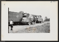 [recto] Evacuee loading crews are seen filling a segregation baggage car with checkable baggages bound for Tule Lake. ;  Photographer: Lynn, Charles R. ;  Denson, Arkansas.