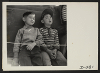 [recto] Manzanar, Calif.--Two small evacuees of Japanese descent at Memorial Day services. Evacuee Boy Scouts took a leading part in the ceremony held at this War Relocation Authority center. ;  Photographer: Stewart, Francis ;  Manzanar, California.