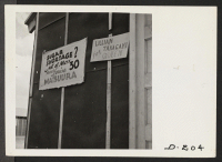 [recto] Signs tacked on barracks advertising Labor Day beauty queen contest which was held at this relocation center. ;  Photographer: Stewart, Francis ;  Newell, California.