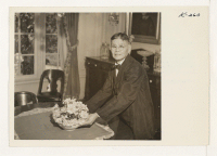 [recto] Mr. Yonekichi Nakata is shown arranging a bowl of flowers in the dining room of the Livingstone estate. Mr. Nakata ...