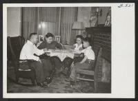 [recto] Enjoying a game of Monopoly at their home in Cleveland, Mr. and Mrs. George Susuma Tabata and their sons, George, ...