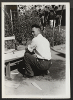 [recto] Evacuee, with lumber furnished by WRA, makes boxes for shipment of personal effects. ;  Newell, California.