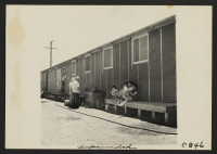 [recto] This is the type of barrack building in the relocation center. Each contains four rooms, to house four family groups. Each has it's own outside entrance, two at the side and one at each end. There are thirty-six blocks of barracks. ;  Photographer: Lang