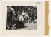 [recto] First evacuee arrivals at Granada assemble alongside the train awaiting bus transportation to the relocation center which is located some 2-1/2 miles away. These evacuees are from Merced Assembly Center, Merced, Calif. ;  Photographer: Parker, Tom ;