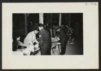 [recto] Hand luggage of newcomers from Tule Lake were inspected at Warehouse 12 immediately after arrival of the trains. ;  Photographer: Lynn, Charles R. ;  Dermott, Arkansas.