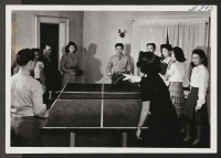 [recto] Table tennis or ping-pong is a popular game with the settlers. Shown here are four near experts at the game. The scene was caught at the Young Kansas Citians' Club. ;  Kansas City, Missouri.